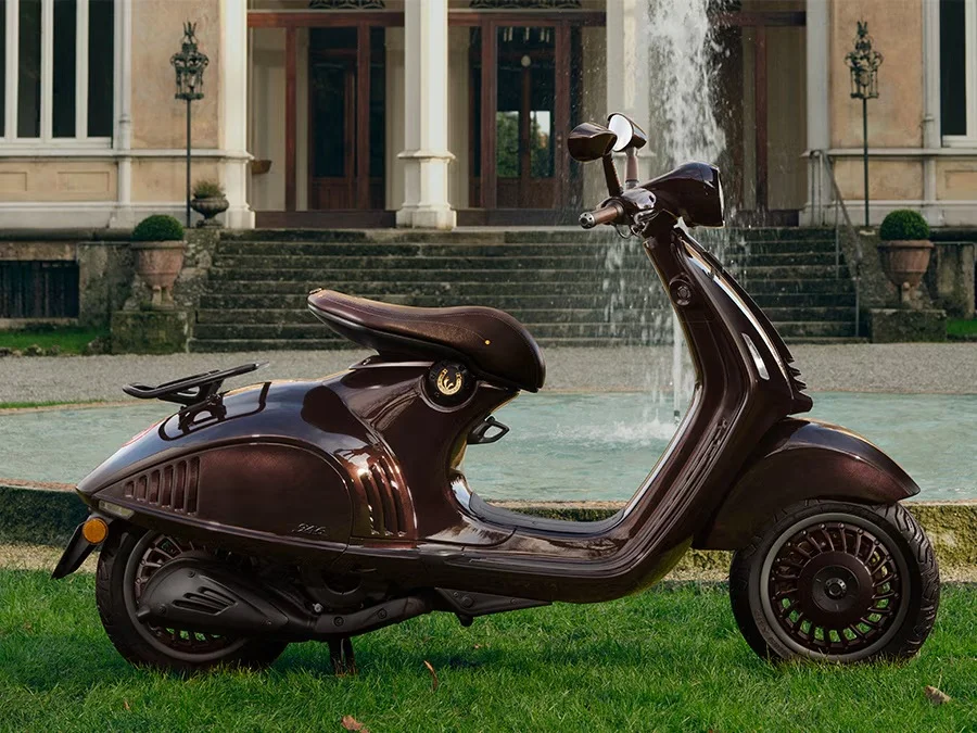 2026 Vespa 946 Horse exterior side profile shown on grass outside a classical stone building.